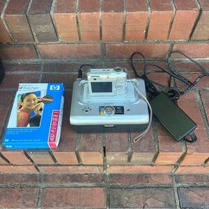 Kodak EasyShare digital camera sitting on a Kodak EasyShare Printer Dock & paper